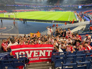 Jovent Gironí camí a l'estadi llençan bengales, les cuals contrasten molt amb la fuscor del cel.